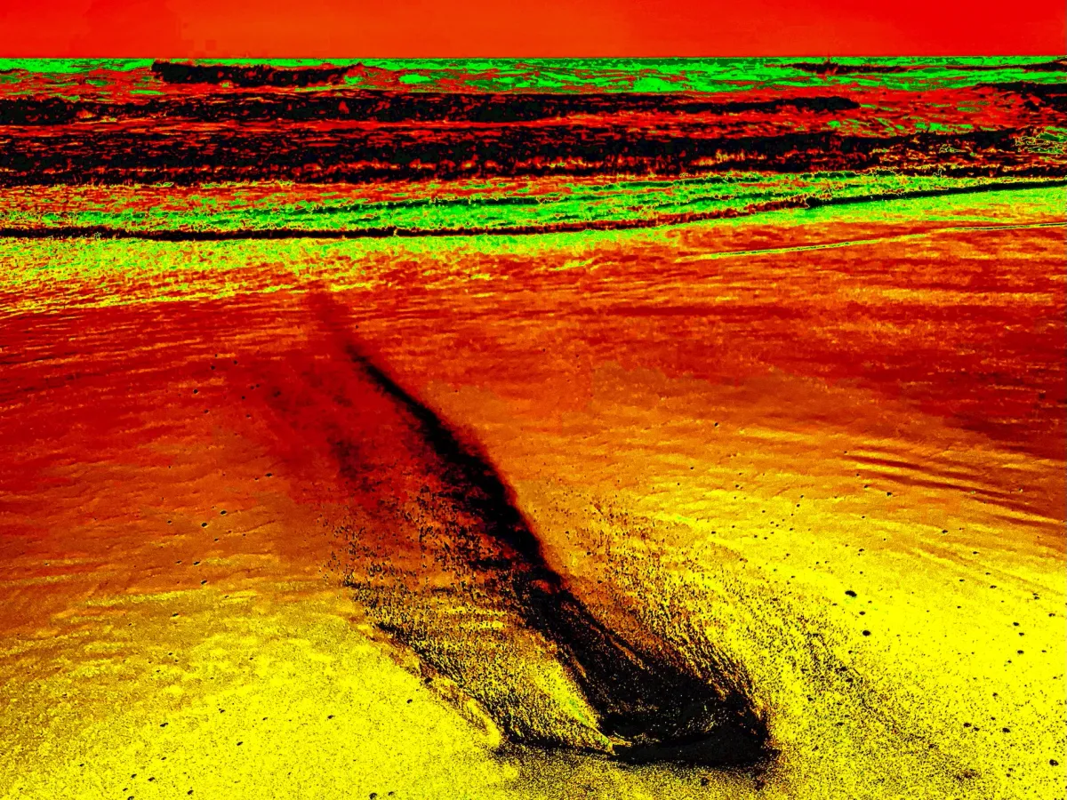 Photo of ashes on a beach being washed away by the tide.